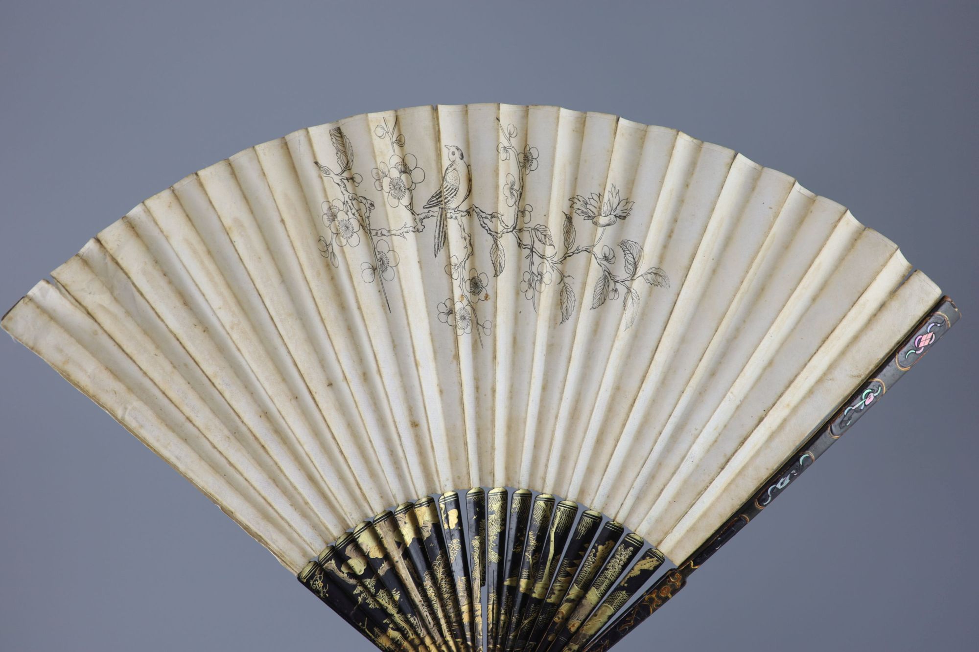 An English painted paper and lacquer fan, late 18th century and a 19th century Chinese embroidered silk purse